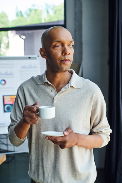 chronic illness, inclusion, african american man with myasthenia gravis disease holding cup of coffee, bold and dark skinned office worker with ptosis syndrome having coffee break  - Foto, afbeelding