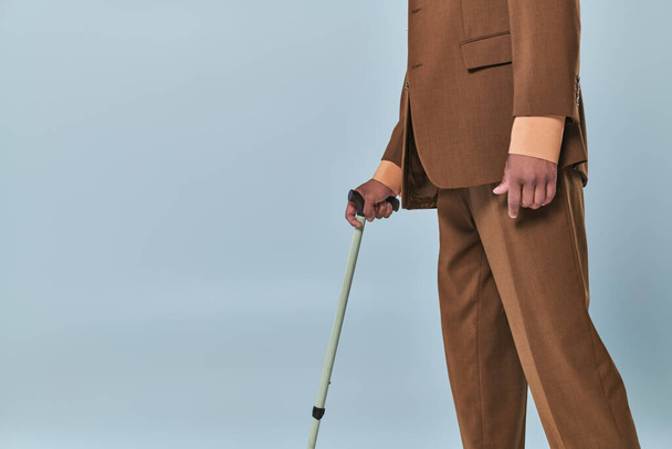 real people, cropped view of african american man leaning on walking cane on grey background, dark skinned person in suit, diversity and inclusion, difficulty walking, autoimmune disease  - Photo, Image