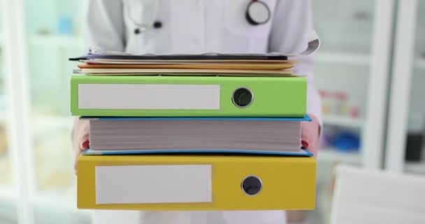 Doctor therapist holds stack of folders in clinic. Medical paperwork and overtime paperwork - Footage, Video