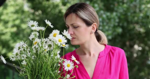 Portrét ženy alergické na divoké jarní květiny a držící kytici v rukou. Dívka foukání nos v kapesníku - Záběry, video