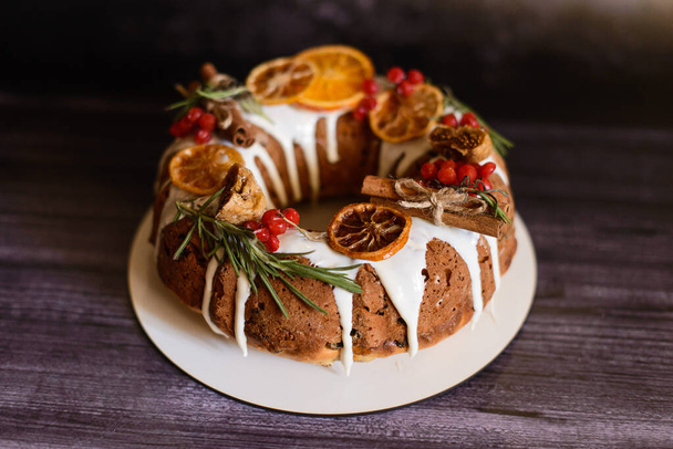 runder Cupcake mit getrockneten Zitrusfrüchten auf weißem Teller und dunklem Hintergrund - Foto, Bild