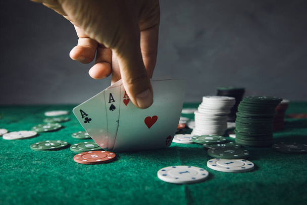 man hand cards playing  poker on green table - Foto, imagen