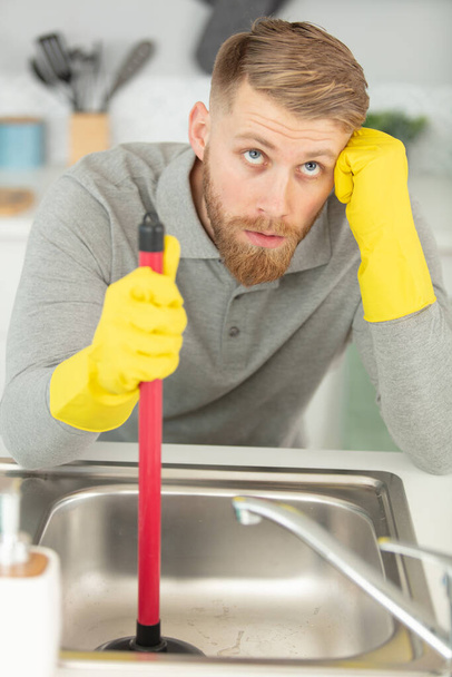close-up of a plumber using plunger in sink - Фото, изображение