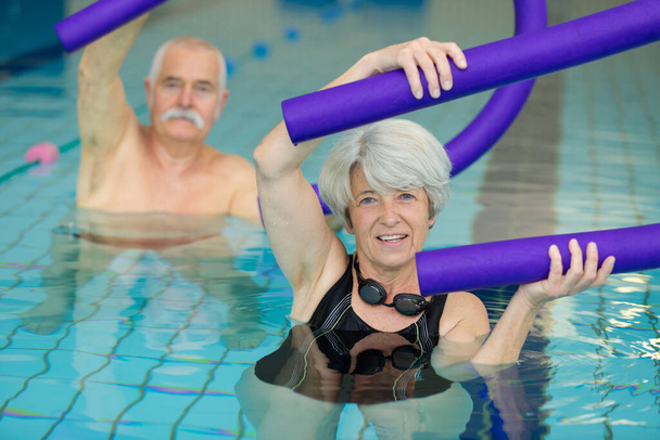 senior people exercising with floats in swimming pool - Fotografie, Obrázek