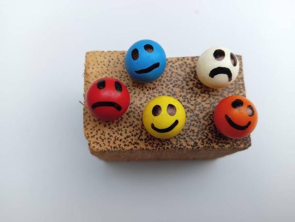 Colourful smileys on wooden piece  - 写真・画像