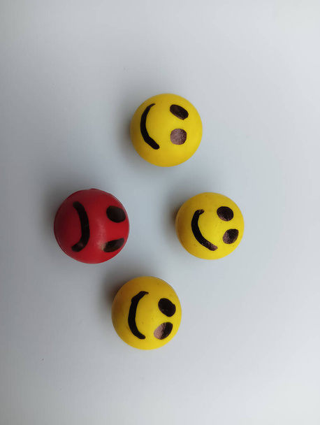 Three happy faces and one sad face on white background  - Fotografie, Obrázek