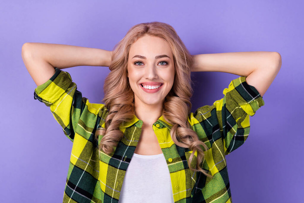 Portret van schattige zorgeloze positieve persoon stralen glimlach armen achter hoofd geïsoleerd op paarse kleur achtergrond. - Foto, afbeelding