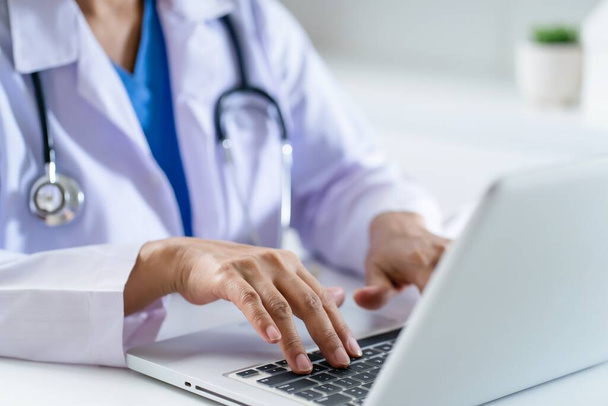 Lekarz skonsultować pacjenta na laptopie z anatomicznym modelem ludzkiego serca Kardiolog wspiera serca Online wizytę lekarza. - Zdjęcie, obraz