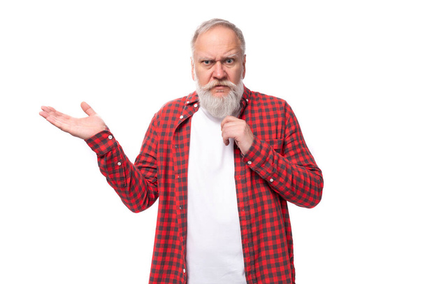 60 ετών ώριμος μεσήλικας άντρας με ένα κομψό πουκάμισο δείχνει το χέρι του στο πλάι. - Φωτογραφία, εικόνα