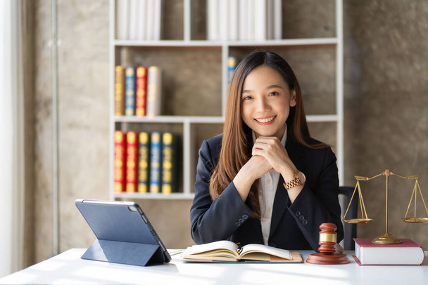 Abogada asiática trabajando en oficina o corte Con escalas de martillo y justicia tableta en mesa de concepto asesoramiento legal en línea - Foto, Imagen