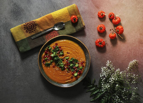 Fresh pumpkin soup topped with parsley and pomegranate seeds - Photo, Image