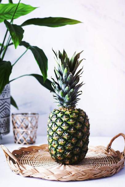 Pineapple in woven bamboo plate on white table - Fotografie, Obrázek