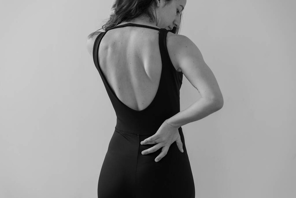 Kobieta, która ćwiczy jogę jest na plecach pokazując cięcie jej odzieży sportowej - Zdjęcie, obraz