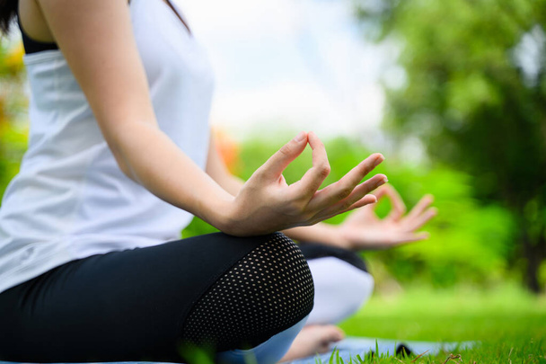 Giovane donna sana che gode e rilassante yoga all'aperto nel parco verde, Donna che fa esercizio di yoga all'aperto con felicità, Donna in forma positiva che pratica yoga all'aperto al mattino - Foto, immagini