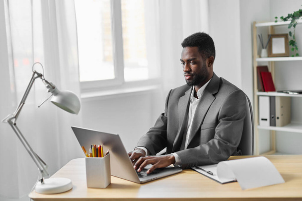 férfi alkalmazott iroda számítógép asztal látszó kibertér munka üzlet afro-amerikai modern diák oktatás laptop üzletember munkás afrikai munka vállalkozó online szabadúszó - Fotó, kép