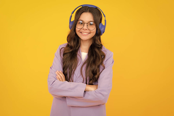Stylish teenage girl listening to music with headphones. Kids lifestyle concept. Wireless earphones - Fotó, kép