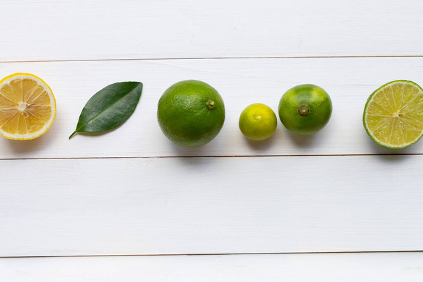 Ripe lemons and limes on white wooden background. - Photo, Image