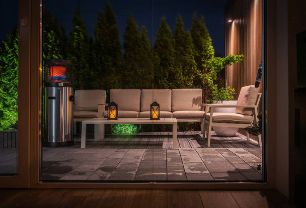 Gemütliche moderne Hinterhof mit Ruhezone am Abend. Blick aus dem Haus. Outdoor Lounge Zone Design. - Foto, Bild