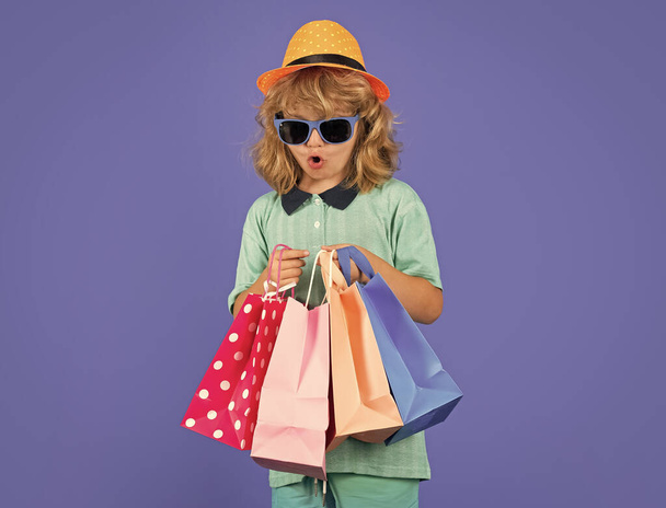 Fashion kid with shopping bag in studio. Little shopper child - Foto, afbeelding