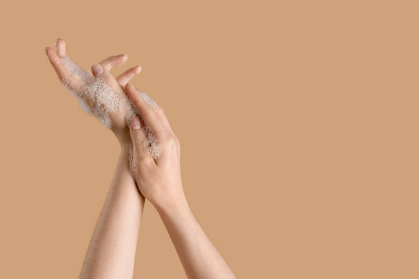 Hands in soap foam on beige background - Photo, Image