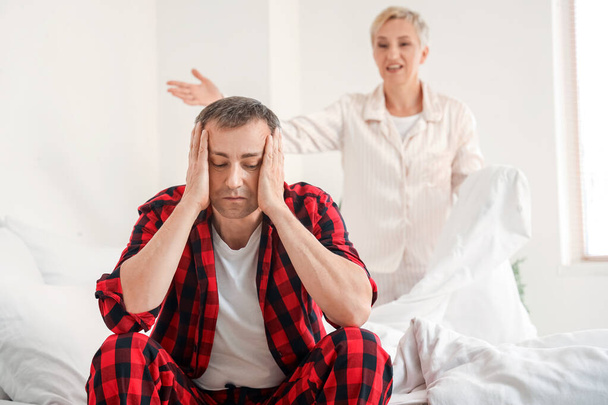 Hombre maduro estresado con su esposa en disputa en el dormitorio - Foto, imagen