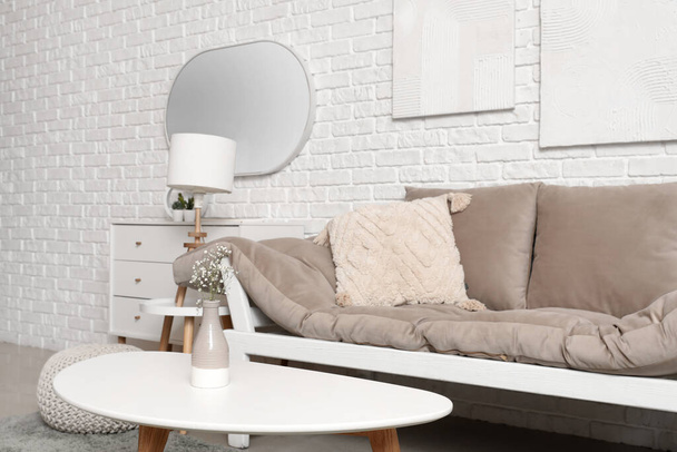 Интерьер светлой гостиной с диваном, журнальным столиком и зеркалом - Фото, изображение
