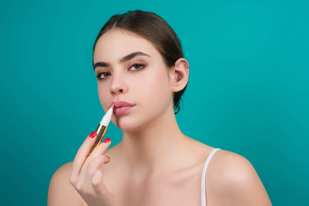Photo of shirtless woman posing with lipstick, isolated studio background. Beautiful woman holding with naked shoulder hold lipstick. Sexy girl using lipstick - 写真・画像