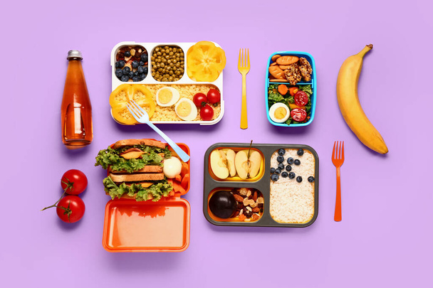 Lunchboxes with different tasty food on lilac background - Foto, Imagen