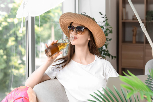 Young woman with beer ready for summer vacation at home - Foto, Bild