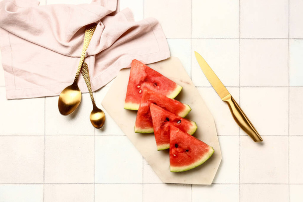 Board with pieces of fresh watermelon on white tile background - Valokuva, kuva