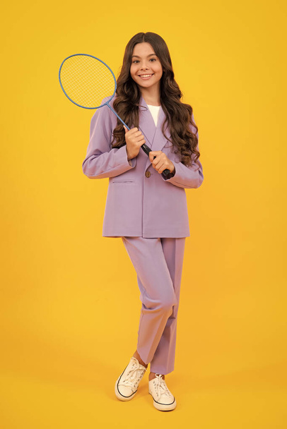 Teen girl badminton player in suit with badminton racket isolated on yellow background - Foto, imagen