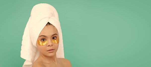 黄金のパッチでシャワータオルで子供の女の子、顔の治療、十代の子供の顔を閉じます。10代の子供のための化粧品やスキンケア、ポスターデザイン。美少女バナーとともにコピースペース - 写真・画像