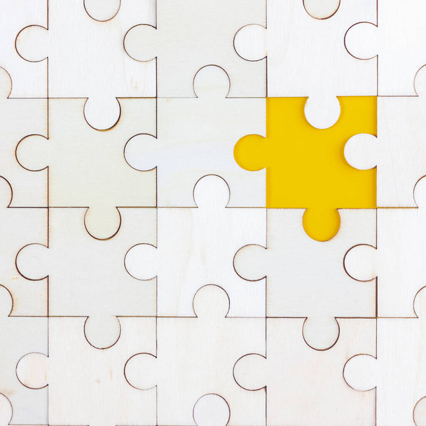 Puzzle en bois blanc sur fond jaune avec espace de copie. Stratégie d'entreprise travail d'équipe ou concept de résolution de problèmes. - Photo, image