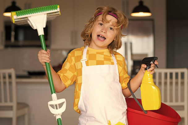 Portrait of child cleaning, concept growth, development, family relationships. Housekeeping and home cleaning concept. Child use duster and gloves for cleaning. Home kitchen background - 写真・画像