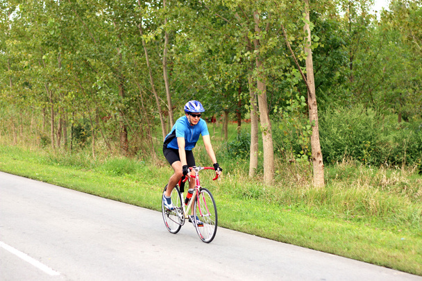 mies pyöräilijä ratsastus pyörä tiellä
 - Valokuva, kuva