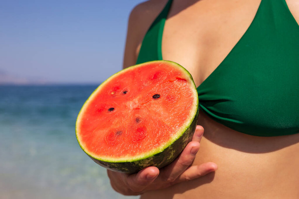 woman eating watermelon at the beach. - Foto, afbeelding