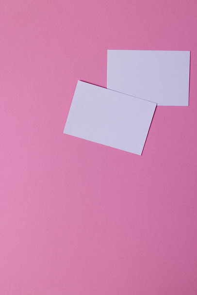 Vertical image of white business cards with copy space on pink background. Business, business card, stationery and writing space concept. - Fotoğraf, Görsel