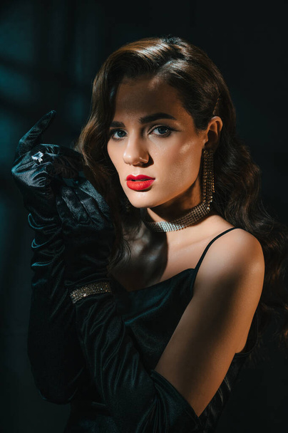 Portrait of brunette woman in classic retro style. Beautiful girl with a hairstyle and makeup with jewelry in vintage retro noir look. Concept of actress from a Hollywood film - Photo, Image