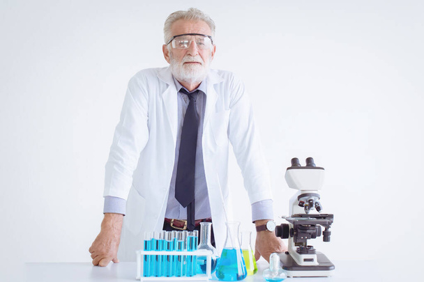 Portré Orvos idősebb tudós kémikus áll a kémiai tudomány ölében mikroszkóppal - Fotó, kép