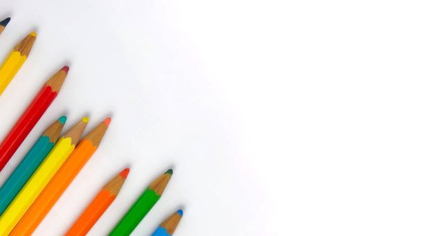 Children's colored pencils dropped on a white sheet diagonally to the left of the image, photo for back to school with space for texts, without background - Foto, Imagem