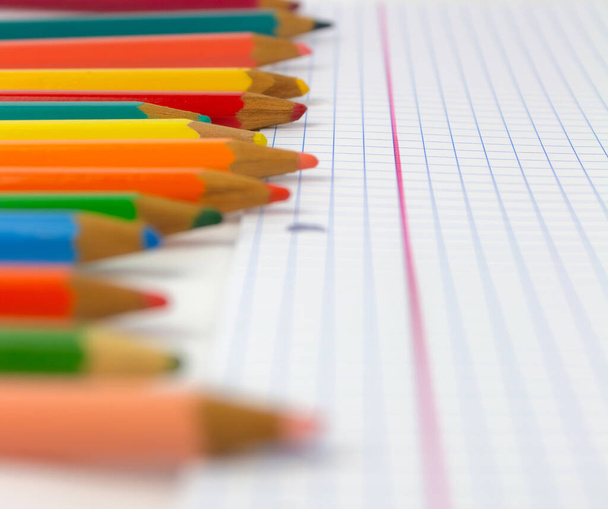 Pencils dropped on a school notebook, distant focus, children's material for back to school - Foto, Imagen