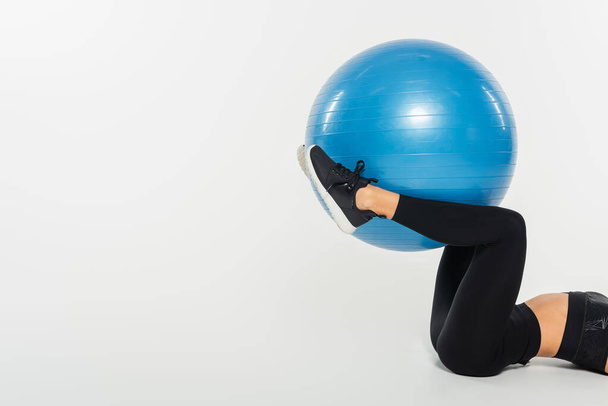 Cropped view of sportswoman exercising with fitness ball on white background, healthy fit concept - Photo, Image