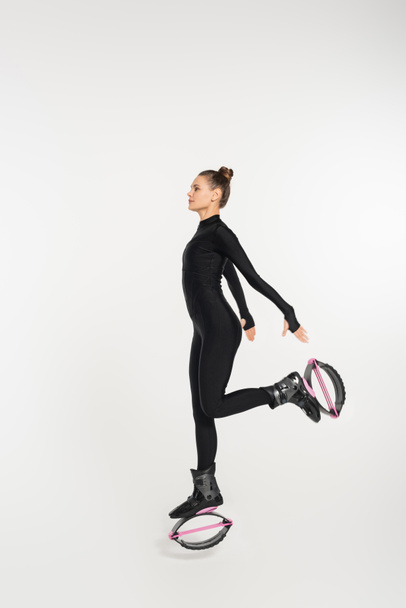 workout and strength, woman in kangoo jumping shoes exercising on white background, jumping boots  - Photo, Image