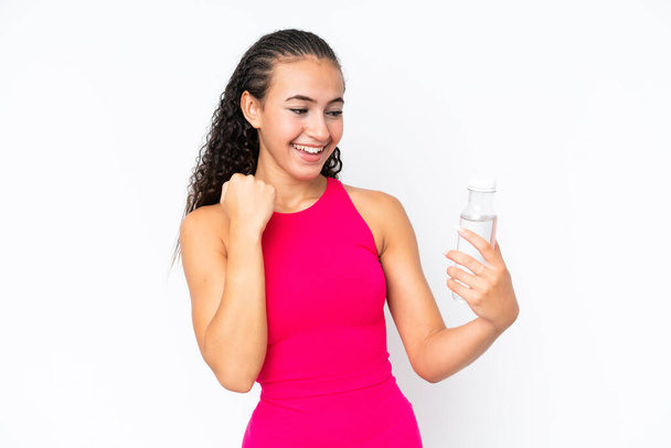 Jeune femme sportive avec une bouteille d'eau isolée sur blanc célébrant une victoire - Photo, image