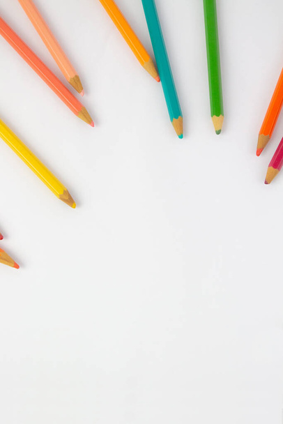 Get closer to the essence of learning with this stock image showing a close-up of colored pencils on a white background. These tools of drawing and artistic expression symbolize the beginning of a new school year full of possibilities. With their sha - Zdjęcie, obraz