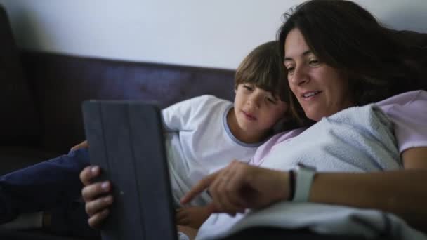 Elämäntapa rento hetki äidin ja lapsen katsomalla sisältöä verkossa tablet-laitteen modernin teknologian - Materiaali, video