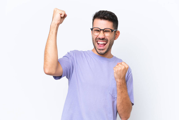 Young caucasian man isolated on white background celebrating a victory - Φωτογραφία, εικόνα