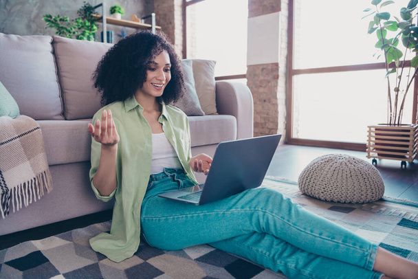 Portrait of charming cheerful lady sitting carpet floors communicate video call wireless netbook modern apartment indoors. - Φωτογραφία, εικόνα
