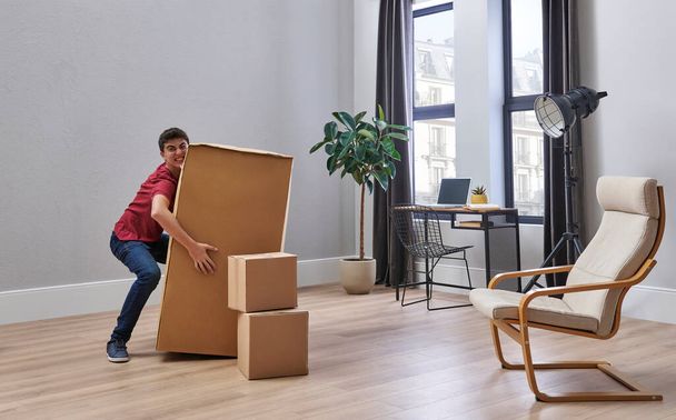 Jonge en tiener man verhuizen naar huis stijl, doos, kamer, interieur concept. - Foto, afbeelding
