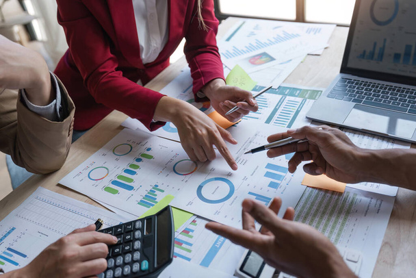 オフィスのアナリストチームは、パフォーマンスと管理を最適化するために、オフィス、グラフとチャートでのマーケティング戦略のための財務データ分析を分析します。. - 写真・画像